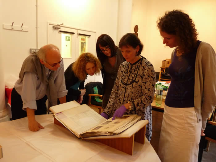 Project personnel looking at a photo album from MAA's Fijian collections