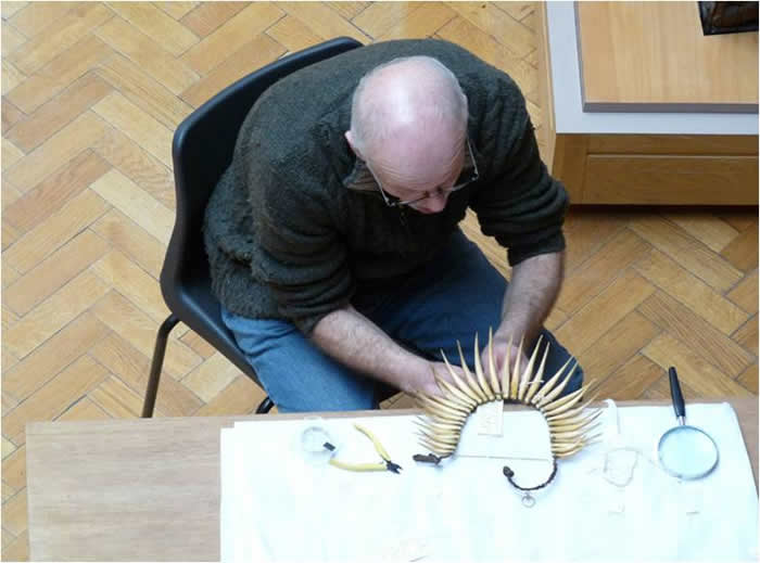 Conservator Bob Bourne working on a Fijian necklace at MAA