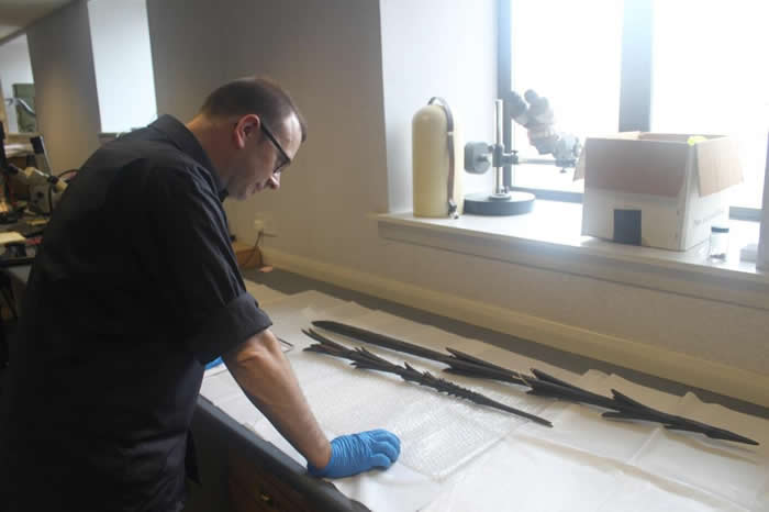 Andy Mills examining a spear in Glasgow